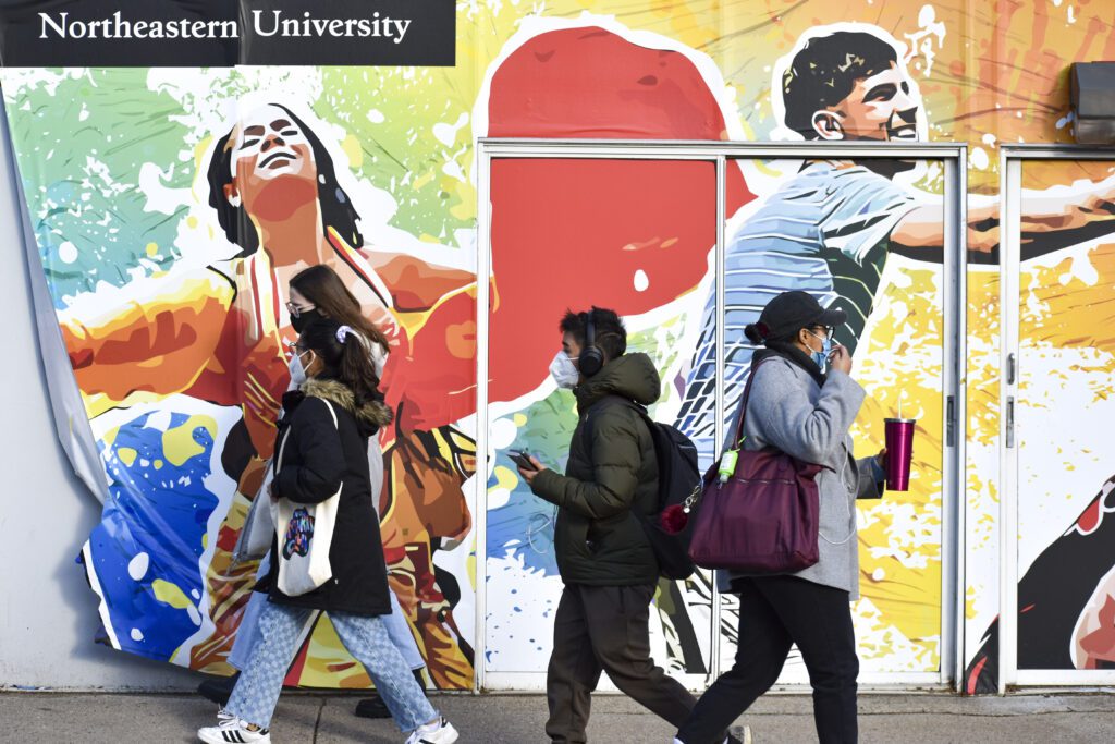 students walking in front of Northeastern University's mural