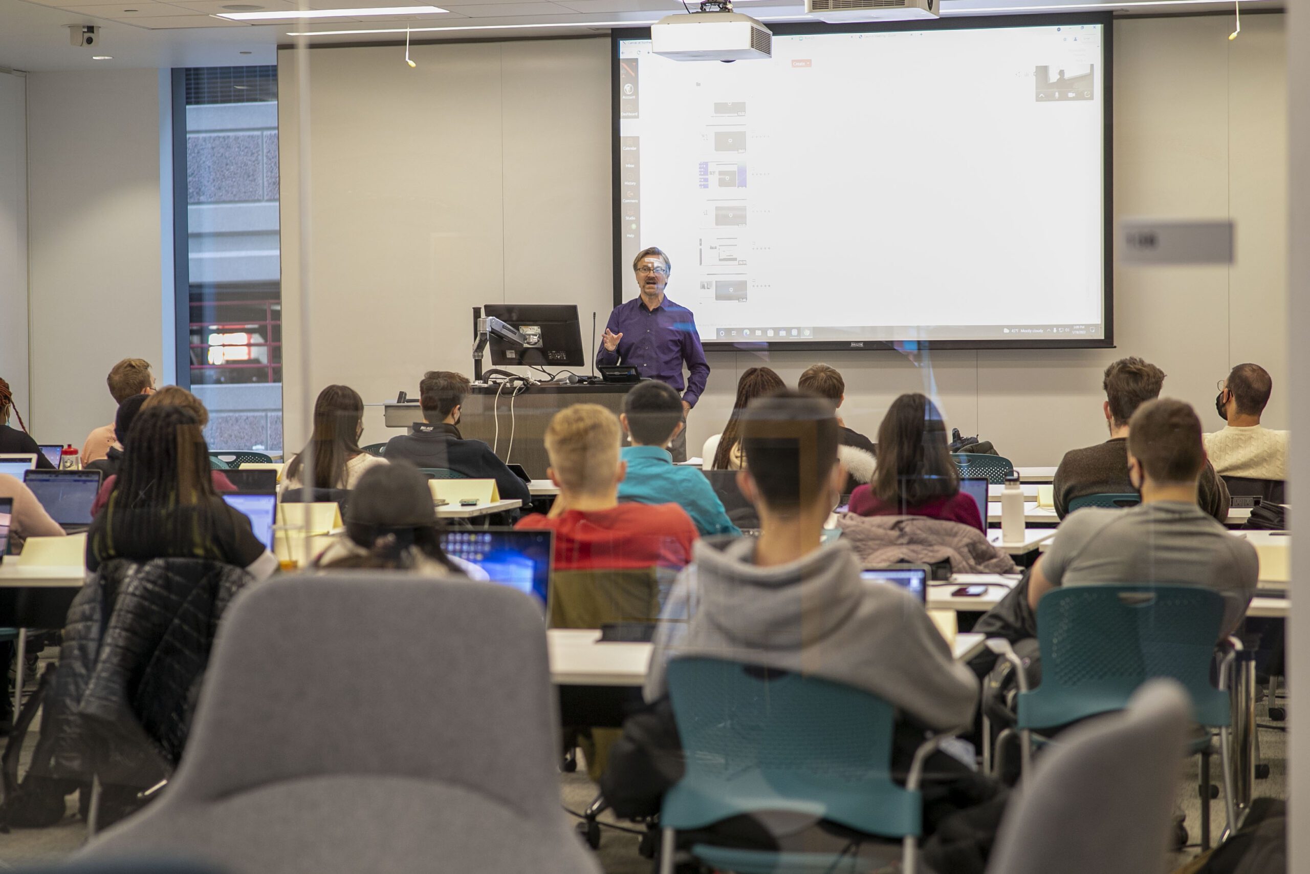 students and a professor teaching in a college classroom
