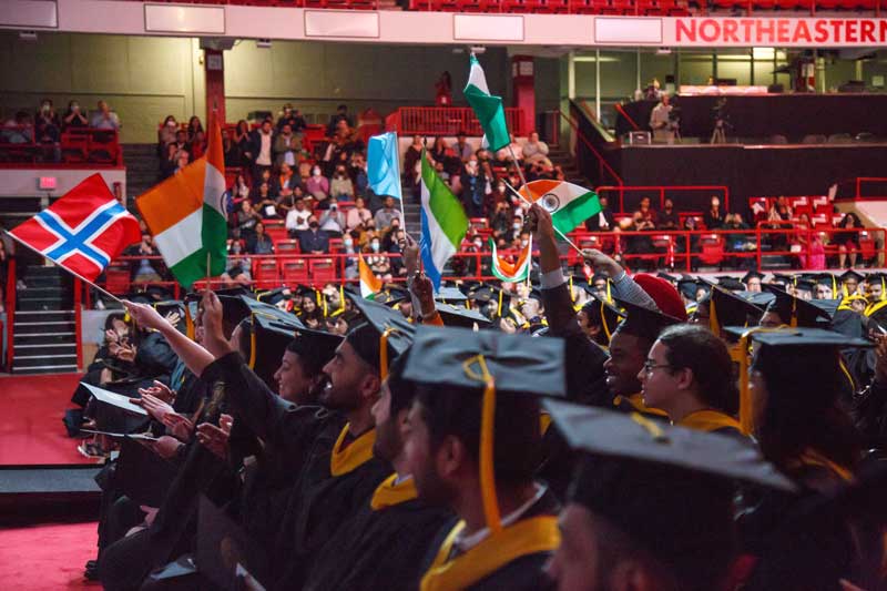 Khoury graduates waive a variety of flags