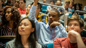A student raises his hand during a lecture