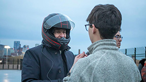 President Aoun talks to a student while wearing his driving helmet