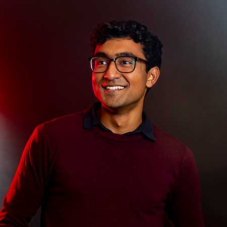 Vivek Kanpa poses in front of a dark background