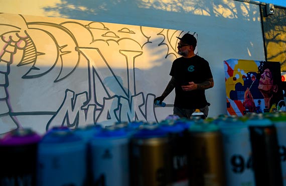 an artist works on a mural at Northeastern Miami's celebration event