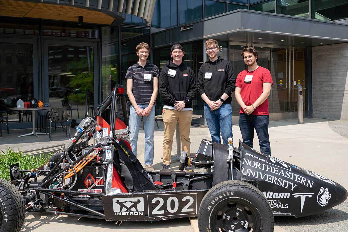 Students who are part of the Northeastern Electric Racing club stand behind their car