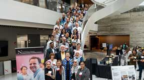 Khoury College faculty gather on the large staircase in the Interdisciplinary Science and Engineering Complex