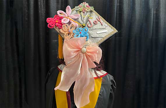 A graduate shows off a decorated cap