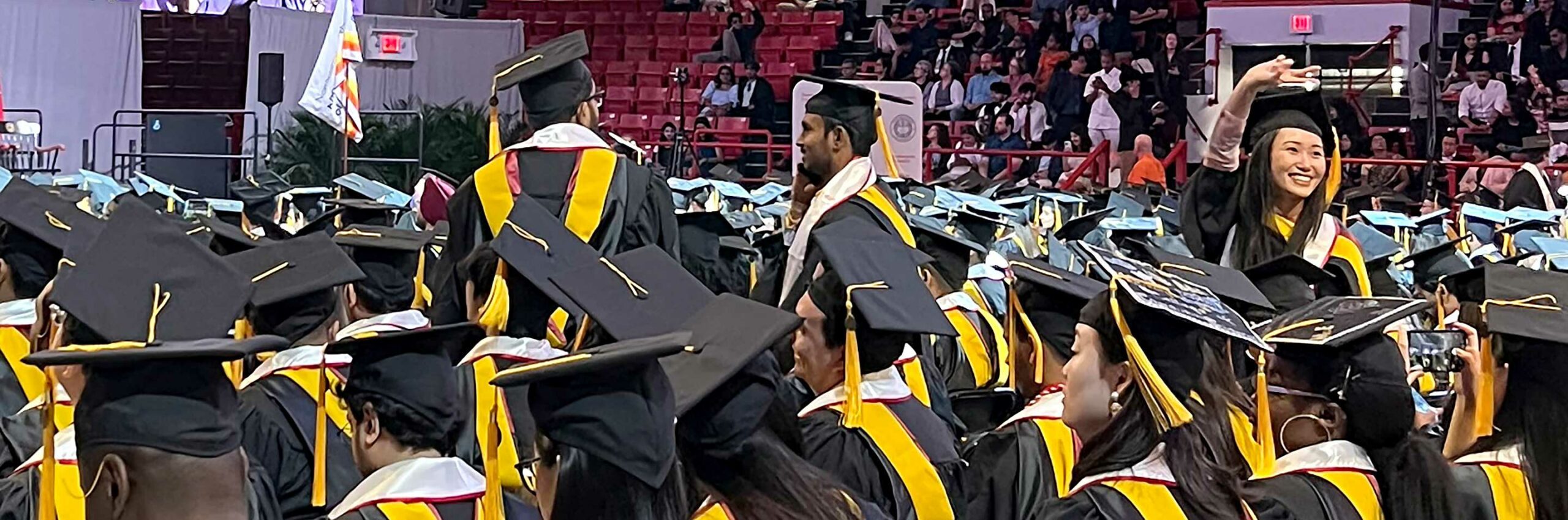 A graduate waves to the crowd during the ceremony