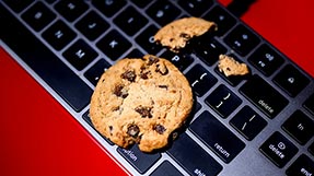 Chocolate cookies are scattered on a computer keyboard