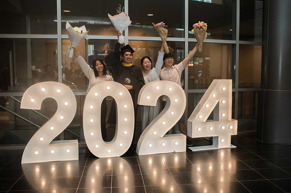 A 2024 in lights was a fitting photographic backdrop for this graduate and his three guests.