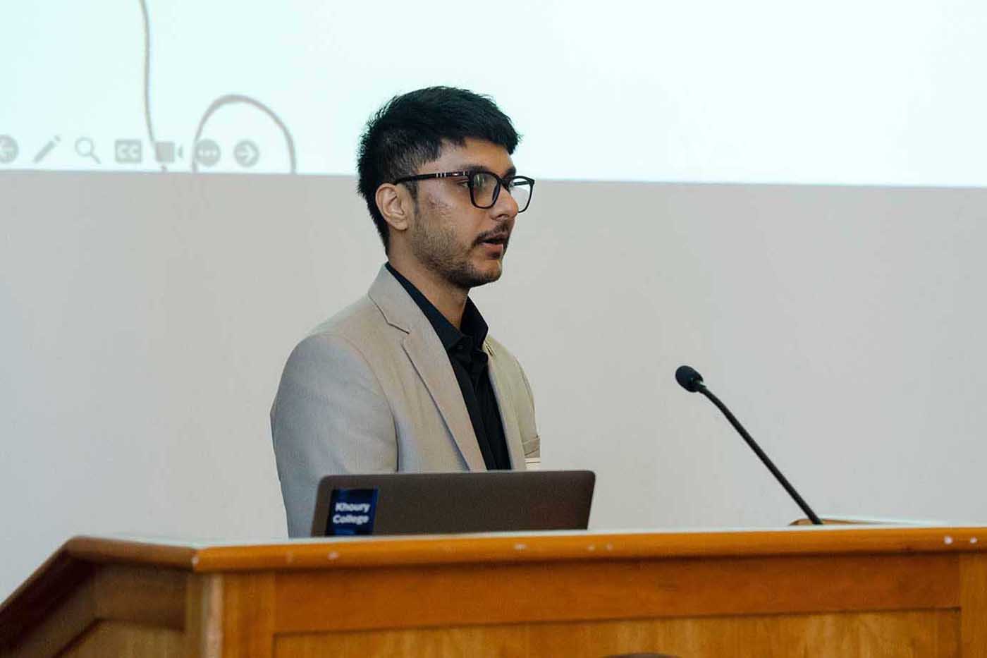 Anish Pawar presents a project while standing behind a podium