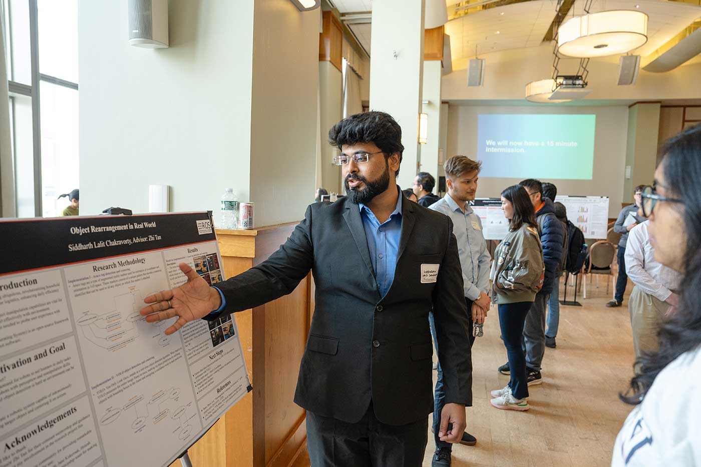 Siddharth Lalit Chakravorty explains his research poster to an onlooker
