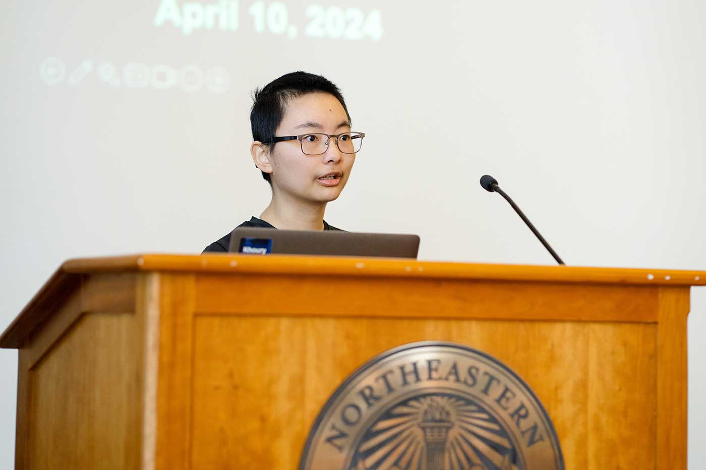 Yuanyuan Yang presents a project while standing behind a podium