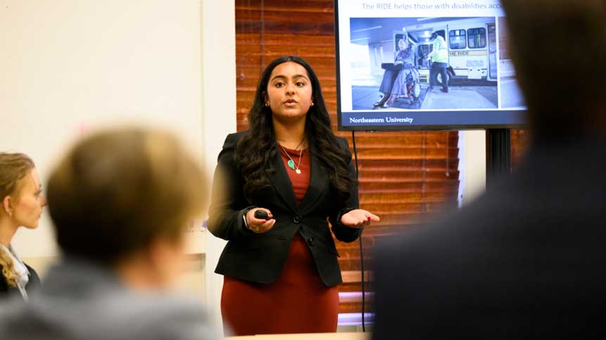 Northeastern student Ria Singh presents a chatbot for employees at The RIDE, the MBTA’s paratransit service, during a visit to the Statehouse. Photo by Matthew Modoono/Northeastern University