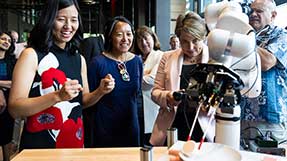 Gov. Maura Healey, Boston Mayor Michelle Wu, left, and state Economic Development Secretary Yvonne Hao, center, learn about AI and robotics.