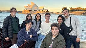 8 Khoury students pose for a photo with the Sydney Opera House in the background