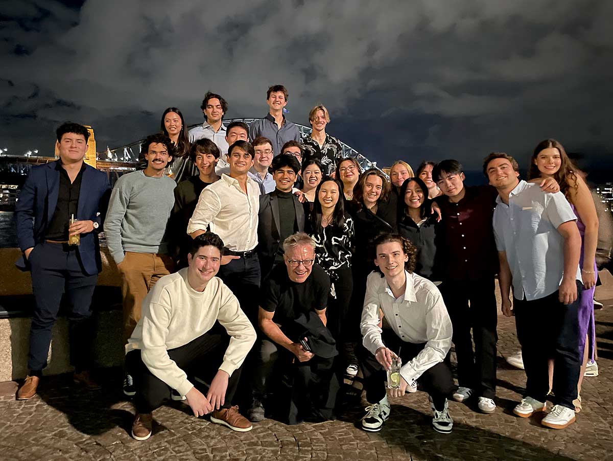 Khoury faculty and photos pose for an outdoor photo at night in Australia